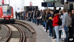 Commuters queue for limited trains during rush hour amid a train drivers strike, at the main railway station in Duisburg, Germany, April 22, 2015. 