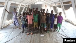 Children, who fled fighting in South Sudan, stand inside a tented classroom at the Bidi Bidi refugee resettlement camp near the border with South Sudan, in northern Uganda, Dec. 7, 2016.