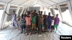 Children, who fled fighting in South Sudan, stand inside a tented classroom at the Bidi Bidi refugee resettlement camp near the border with South Sudan, in northern Uganda, Dec. 7, 2016.