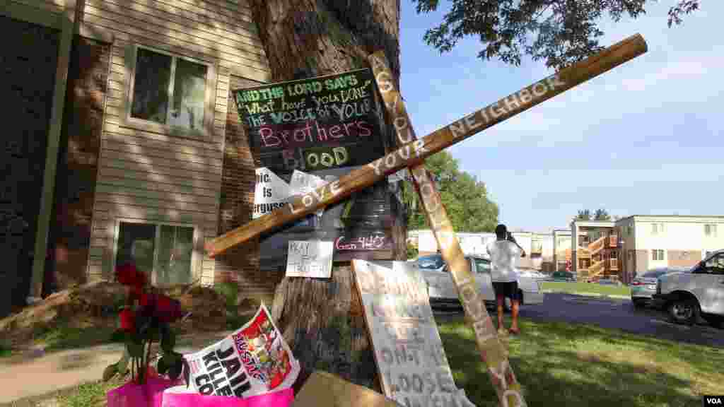 Una enorme cruz con distintas frases conciliatorias hacen un llamado para la paz, luego de dos semanas de protestas y enfrentamientos con la policía en la ciudad de Ferguson, Missouri. [Foto: Gesell Tobias, VOA]