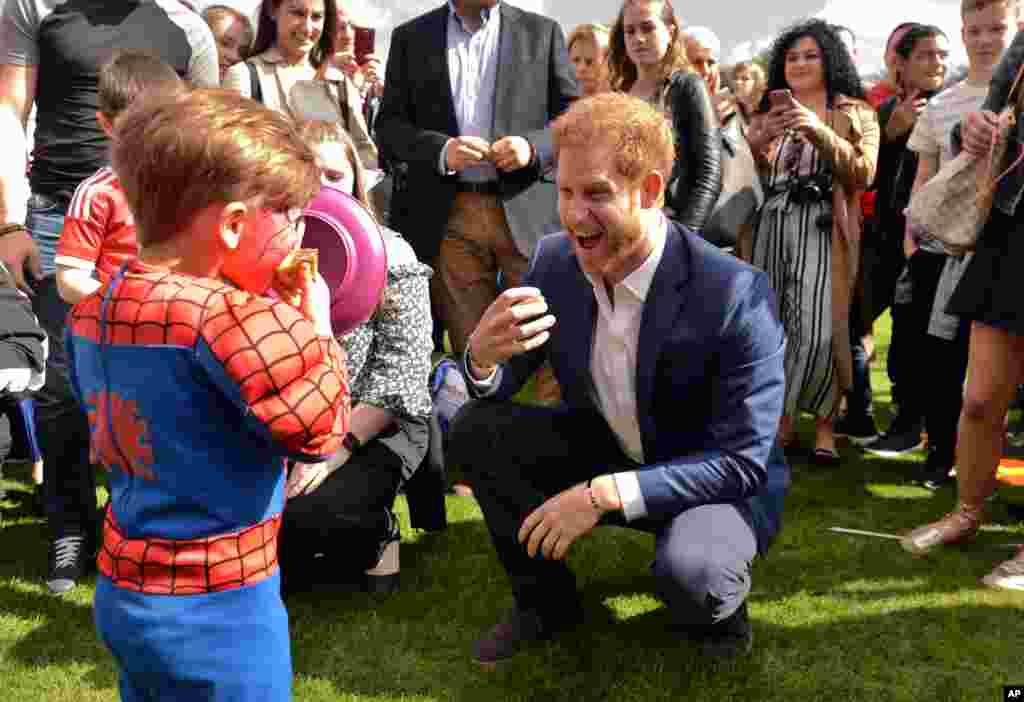 بازی شاهزاده هری با یک کودک در جشنی در کاخ باکینگهام در لندن.