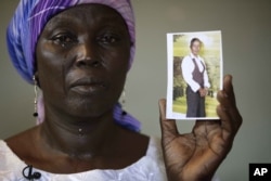 FILE - Martha Mark, mother of kidnapped schoolgirl Monica Mark, cries as she displays her photo in the family's house in Chibok, Nigeria, May 19, 2014