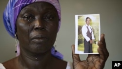 FILE - Martha Mark, mother of kidnapped schoolgirl Monica Mark, cries as she displays her photo in the family's house in Chibok, Nigeria, May 19, 2014