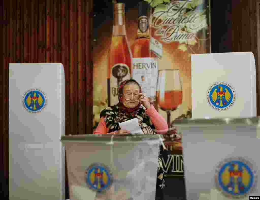 A woman casts her ballot during a parliamentary election at a polling station in Laloveni near Chisinau, Moldova, Nov. 30, 2014.