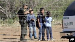 Imigran anak-anak bersama petugas patroli perbatasan di Laredo, Texas. (Foto: Dok)