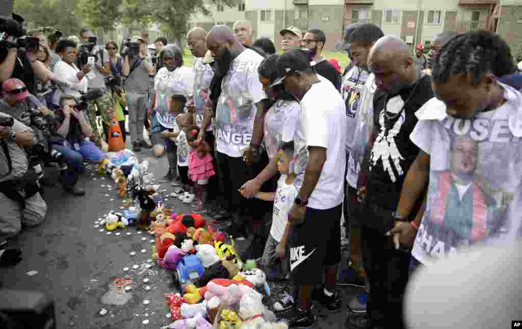 Michael Brown Sr., com sua família e amigos, rezando num memorial dedicado ao seu filho antes de participar no protesto na cidade de Ferguson, 8 de Agosto, 2015.
