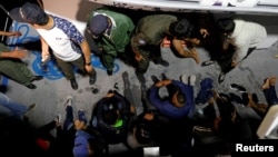 FILE - Migrants are seen on a boat after being rescued by Tunisia's coast guard, off the coast of Bizerte, Tunisia, Oct. 12, 2017.