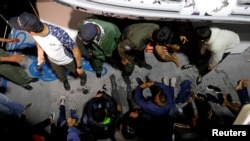 FILE - Migrants are seen on a boat after being rescued by Tunisian coast guard, off the coast of Bizerte, Tunisia. Taken Oct. 12, 2017.
