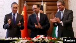 中国外长王毅和阿富汗外长拉巴尼（中）与巴基斯坦外长库雷希（右）在喀布尔签署反恐备忘录后鼓掌。（2018年12月15日）