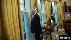 El presidente de los Estados Unidos, Donald Trump, mira por la ventana de la Oficina Oval tras una entrevista con Reuters en la Casa Blanca en Washington, EE.UU., el 27 de abril de 2017.