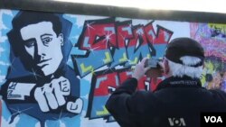 Tourists take photos of Berlin Wall, March 2, 2013.