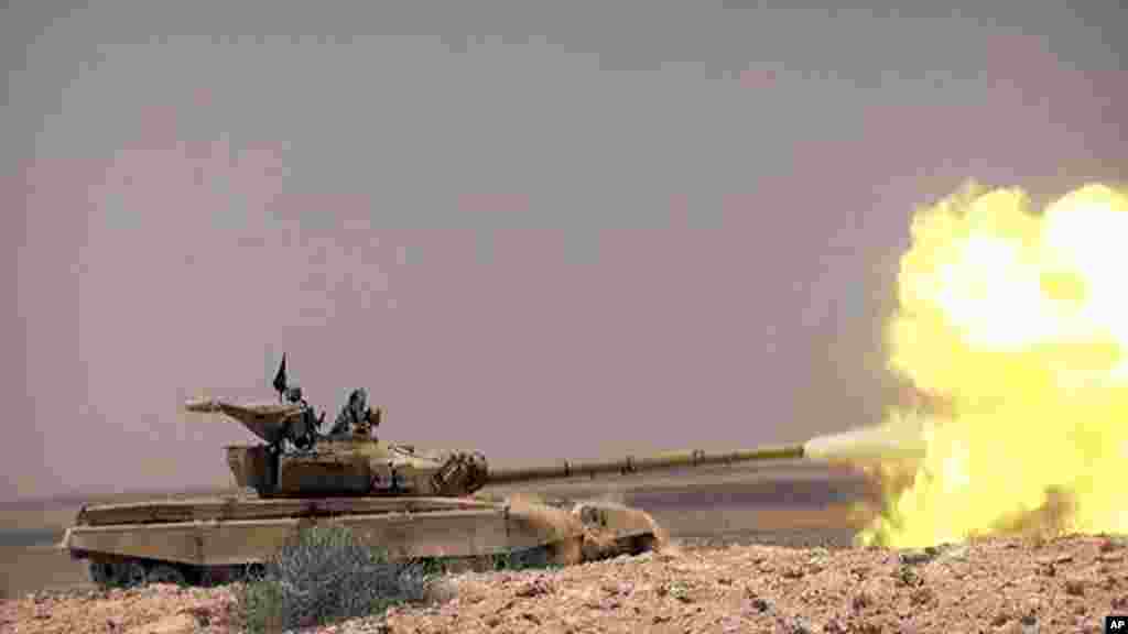 Foto ini dirilis Rabu (20/5) oleh situs militan ISIS, menunjukkan sebuah tank dengan para pejuang ISIS bertempur dengan pasukan pemerintah Suriah di sebuah jalan antara Homs dan Palmyra, Suriah.