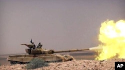 Esta foto divulgada el 20 de mayo muestra a militantes del grupo Estado islámico disparando un tanque contra las fuerzas gubernamentales sirias.
