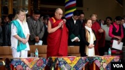 Le Dalai Lama (centre) en train de prier