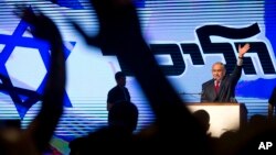 Israel's Prime Minister Benjamin Netanyahu waves during his Likud Party conference in Tel Aviv, Israel, Aug. 9, 2017. Netanyahu, lashed out at the media and his political opponents in an animated speech to hundreds of enthusiastic supporters on Wednesday, seeking to deliver a powerful show of force as he battles a slew of corruption allegations that have threatened to drive him from office.