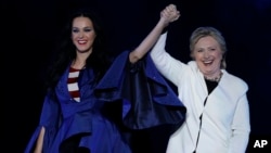 Katy Perry, left, holds hands with Democratic presidential nominee Hillary Clinton during a concert at the Mann Center for the Performing Arts, Nov. 5, 2016, in Philadelphia.