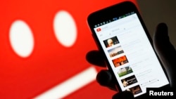 A picture illustration shows YouTube on a cell phone, in front of a YouTube copyright message regarding a video on an LCD screen.
