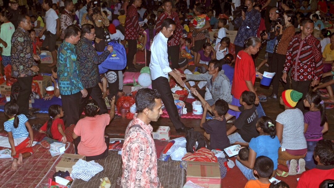 Indonesian President Joko Widodo, center, greets villagers at an evacuees' camp in Klungkung, Bali, Indonesia, Sept. 26, 2017. Warnings that a volcano on the Indonesian tourist island of Bali will erupt have sparked an exodus of nearly 100,000 people.