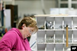 FILE - A worker builds shelves for an Airstream travel trailer at the Airstream factory, in Jackson Center, Ohio, Oct. 22, 2014.