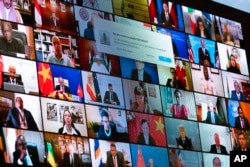 World leaders are shown on a screen as President Joe Biden speaks to the virtual Leaders Summit on Climate, from the East Room of the White House, Friday, April 23, 2021, in Washington. (AP Photo/Evan Vucci)