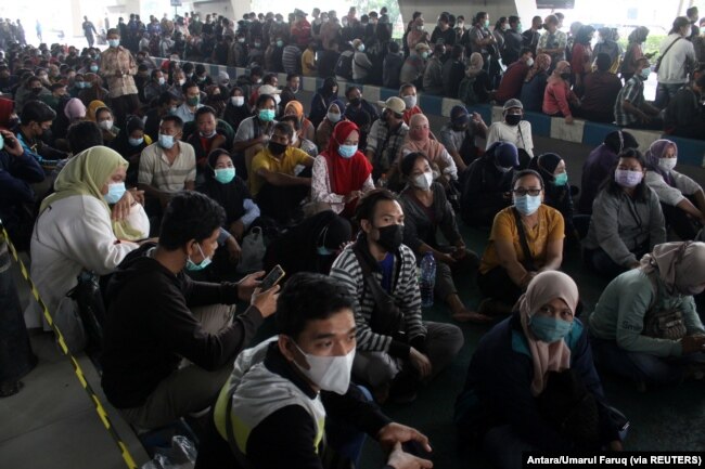 Masyarakat sedang mengantre untuk mendapatkan vaksin COVID-19 di Bandara Internasional Juanda, saat kasus melonjak di Sidoarjo, Jawa Timur, 22 Juli 2021. (Foto: Antara/Umarul Faruq via REUTERS)