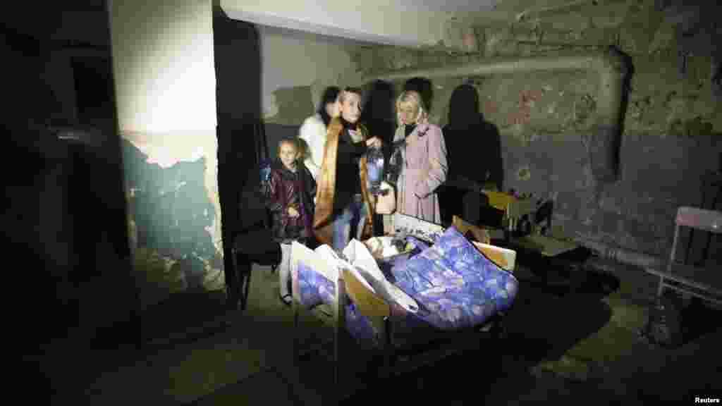 Parents and a pupil hide in a school basement used as a shelter after recent shelling in Donetsk, eastern Ukraine, Oct. 1, 2014. 
