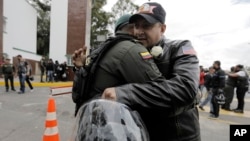 A man embraces a police officer, outside the General Francisco de Paula Santander Police Academy, a day after a car bomb exploded at the site, in Bogota, Colombia, Jan. 18, 2019. Colombia blamed the National Liberation Army, ELN, rebels for the deadly attack.