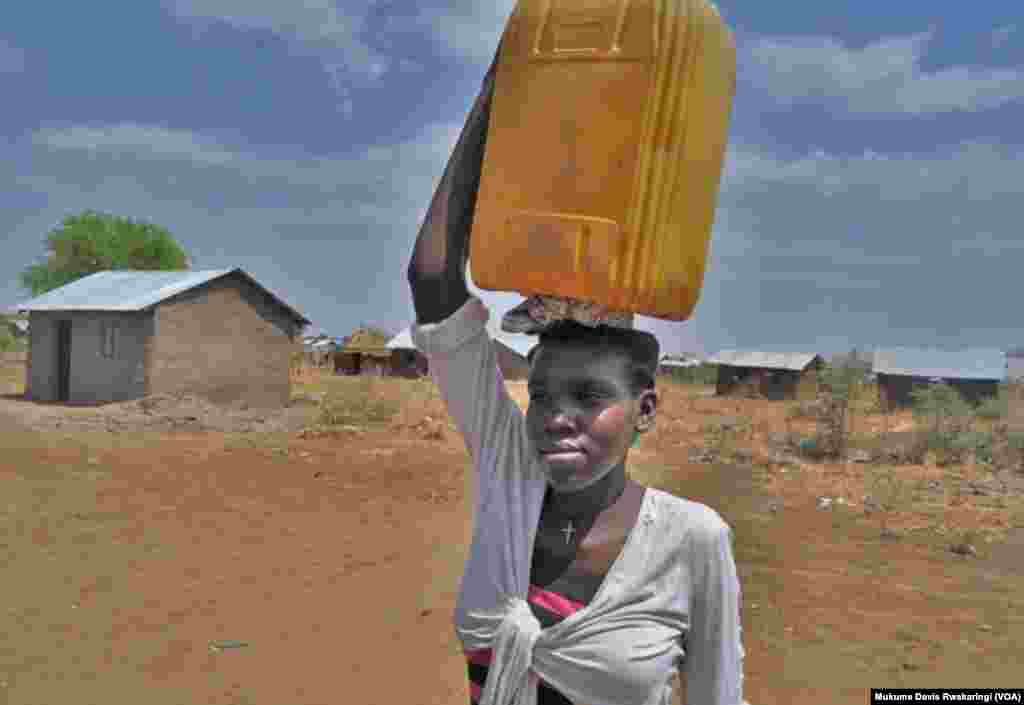 A young woman carries a plastic container to collect water in Gudere, near Juba in South Sudan. Only half the population of South Sudan has access to clean water. (VOA/Mugume Davis Rwakaringi) 