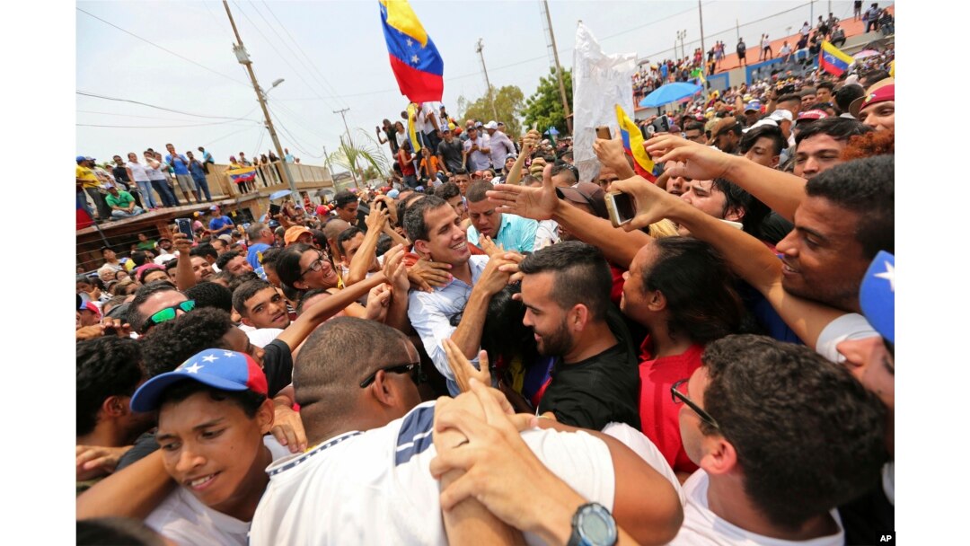 Juan Guaidó, opposition leader and self-proclaimed interim president of Venezuela, is surrounded by supporters at the end of a rally on the shore of Lake Maracaibo in Cabimas, Venezuela, April 14, 2019.