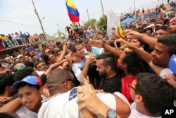 Juan Guaidó, líder de la oposición y autoproclamado presidente interino de Venezuela, está rodeado de simpatizantes al final de un mitin en la orilla del lago Maracaibo en Cabimas, Venezuela, el 14 de abril de 2019.