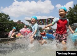 서울에 폭염주의보가 내려진 25일 송파구 성내천 물놀이장을 찾은 어린이들이 더위를 식히고 있다.