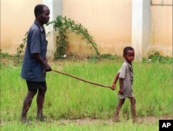 FILE - A child leads a man affected by river blindness in Gbarnga, Liberia, Sept. 4, 1995.