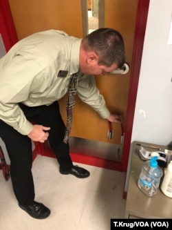 Westside Consolidated School District Superintendent Scott Gauntt demonstrates how to apply a U-lock bolt, which is standard in every classroom, Dec. 4, 2018. The school in Jonesboro, Ark., was the scene of a deadly school shooting in 1998. (T.Krug/VOA Ne