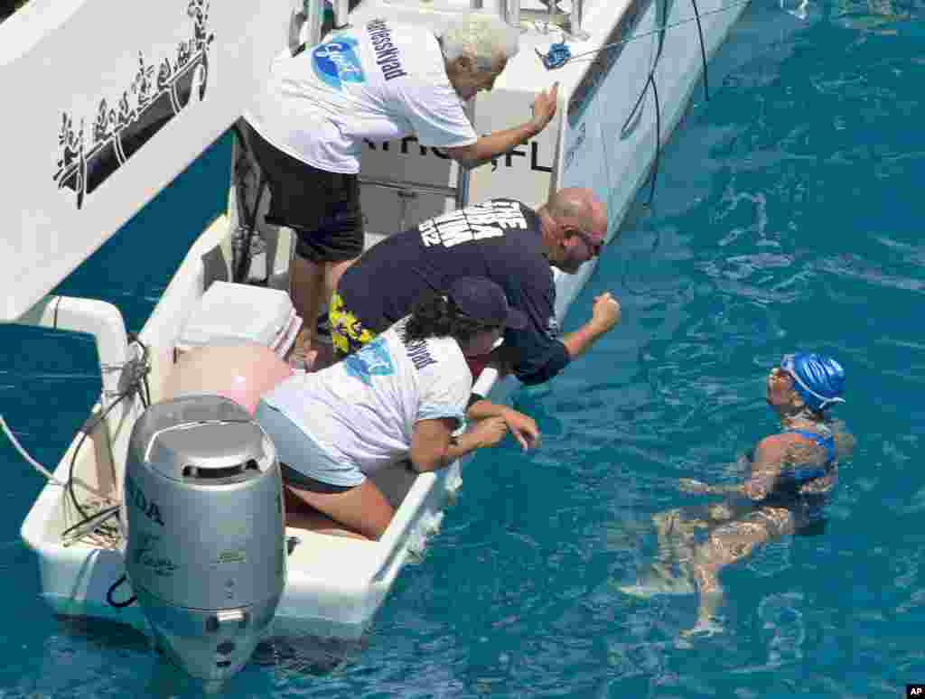 In this photo provided by the Florida Keys News Bureau, swimmer Diana Nyad talks with her crew about three kilometers off Key West, Florida, Sept. 2, 2013.