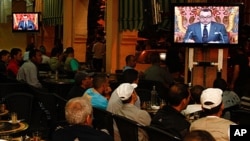 Moroccan customers at a cafe in Casablanca watch a live broadcast from Rabat of a speech by Morocco's King Mohammed VI, June 17, 2011
