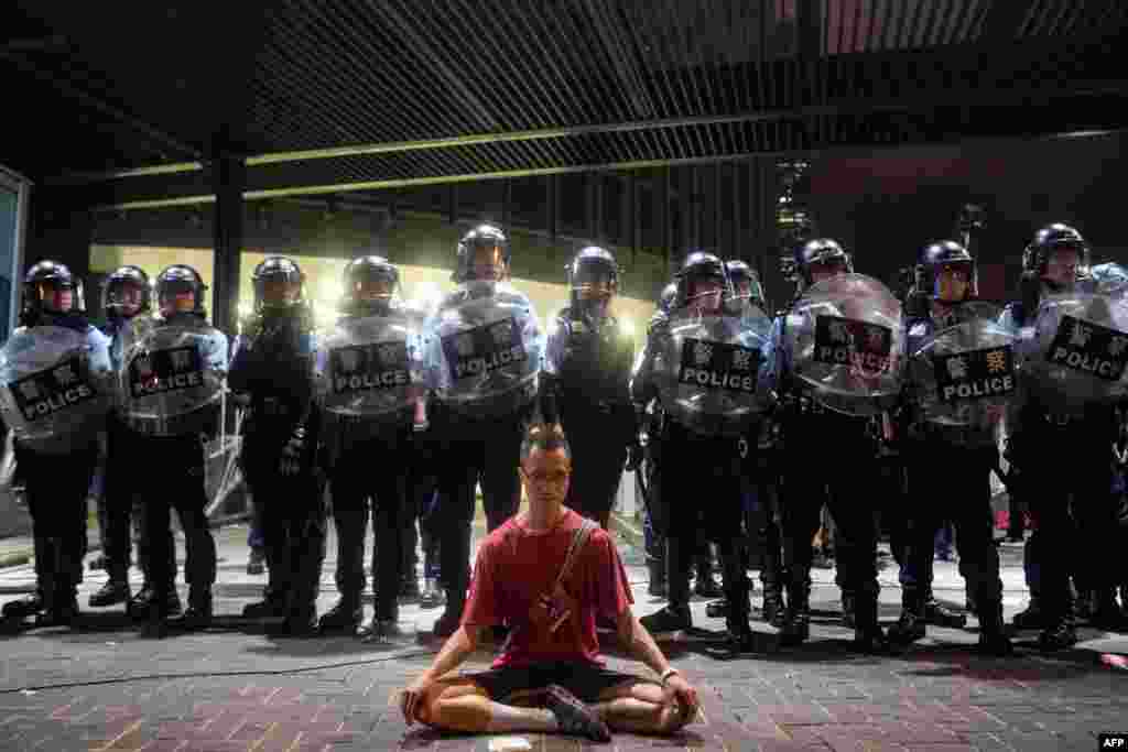 A protester meditates in front of police in Hong Kong, June 10, 2019. Hong Kong witnessed its largest street protest in at least 15 years as crowds massed against plans to allow extraditions to China, a proposal that has sparked a major backlash against the city&#39;s pro-Beijing leadership.