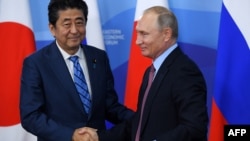 블라디미르 푸틴 러시아 대통령과 아베 신조 일본 총리가 10일 블라디보스톡에서 정상회담에 앞서 악수하고 있다.
