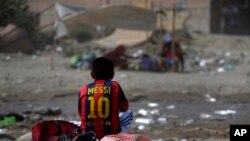 En esta foto del 24 de marzo de 2017, un sobreviviente de inundaciones, vistiendo una camiseta del Lionel Messi del FC Barcelona, come su almuerzo en Carapongo, Perú.