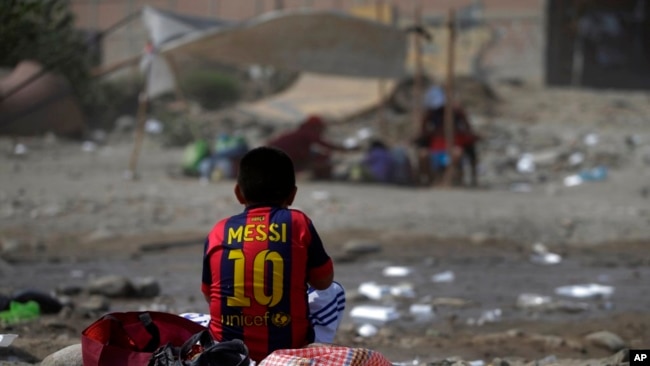 En esta foto del 24 de marzo de 2017, un sobreviviente de inundaciones, vistiendo una camiseta del Lionel Messi del FC Barcelona, come su almuerzo en Carapongo, Perú.