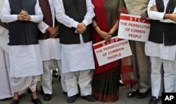 Indian lawmakers from opposition parties hold placards in the parliament premises during a protest against the government demonetizing high-value bills in New Delhi, India, Wednesday, Nov. 23, 2016.