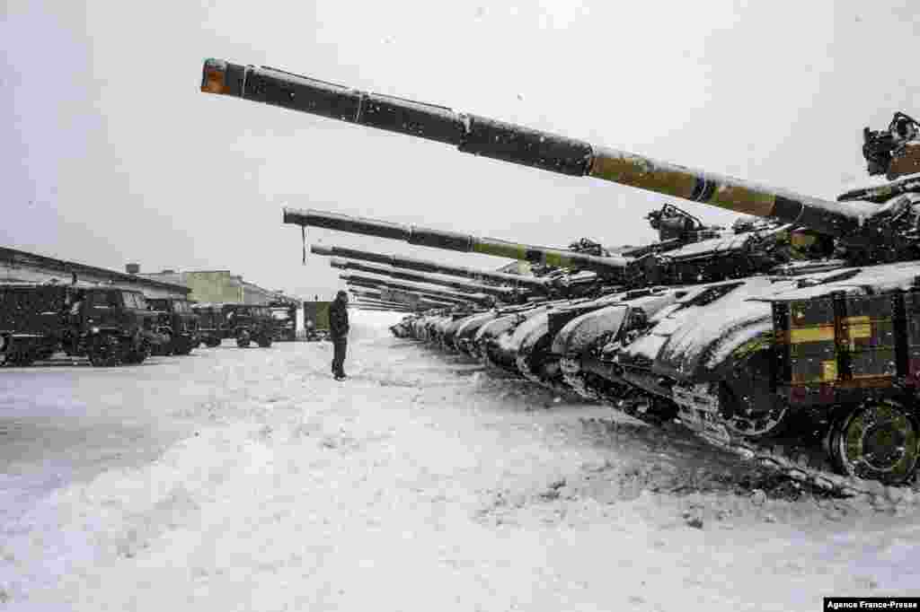 An Ukrainian Military Forces serviceman stands in front of tanks of the 92nd separate mechanized brigade of Ukrainian Armed Forces, parked in their base near Klugino-Bashkirivka village, in the Kharkiv region.