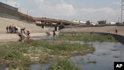 Familias migrantes cruzan el Río Grande, cruzando ilegalmente la frontera con Estados Unidos, para entregarse a las autoridades en busca de asilo a través del Puente Internacional Paso del Norte, El Paso, Texas, 2019.  31 de mayo de 2019.