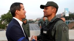 Lãnh đạo phe đối lập Venezuela Juan Guaido, người được nhiều quốc gia công nhận là lãnh đạo lâm thời hợp pháp của đất nước, bắt tay với một giới chức quân sự gần căn cứ không quân Generalisimo Francisco de Miranda "La Carlota", ở Venezuela, ngày 30/4/019. 