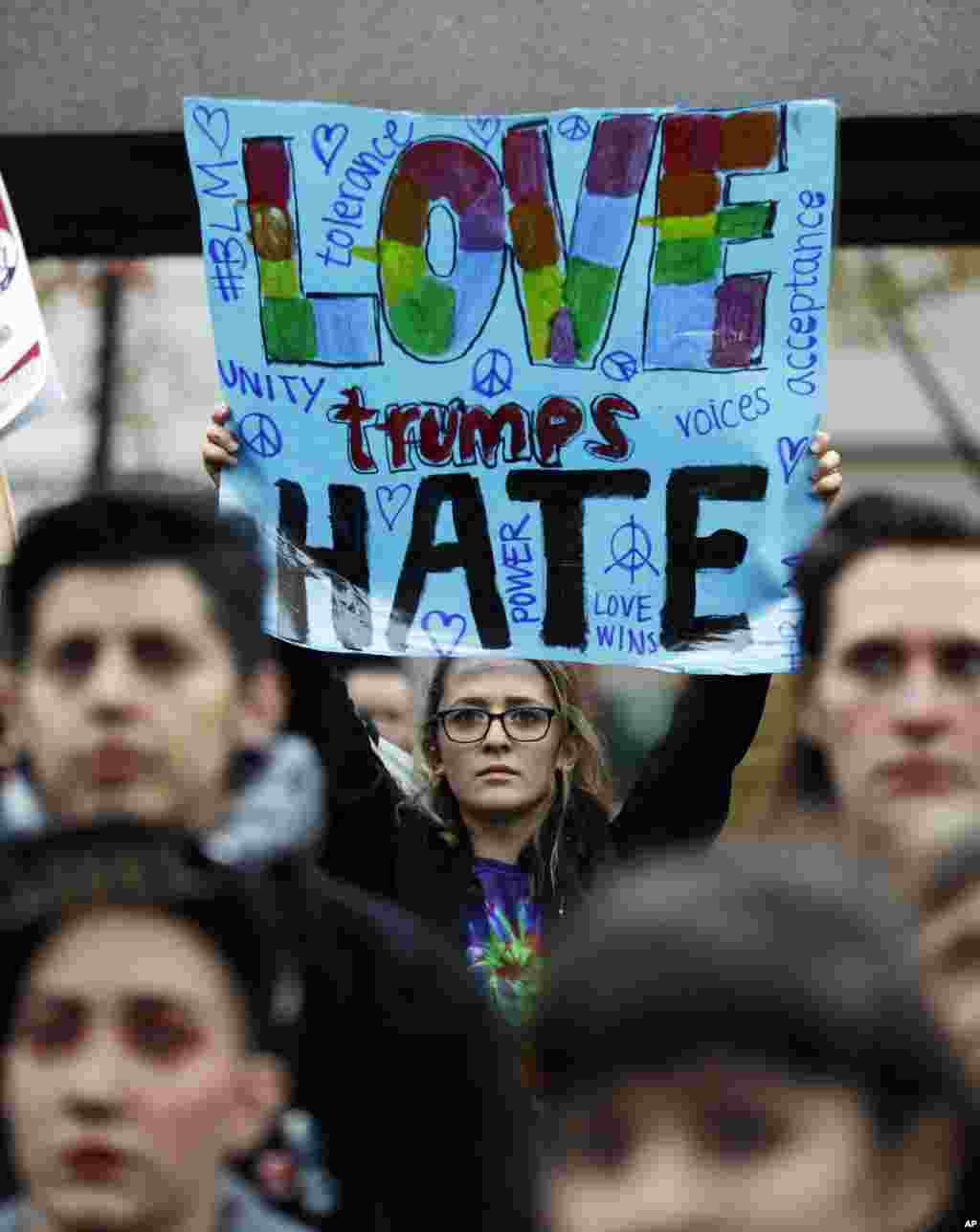 A protester holds a sign that reads "Love Trumps Hate" during a protest against the election of President-elect Donald Trump, in downtown Seattle, Nov. 9, 2016.