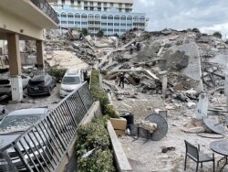 Para petugas penyelamat terus bekerja di reruntuhan gedung apartemen di Miami Beach, Florida, Kamis (24/6).