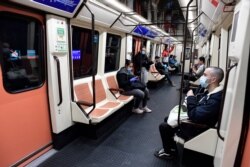 Pasajeros usan mascarillas mientras viajan en un tren en la estación Atocha en Madrid el 13 de abril de 2020.