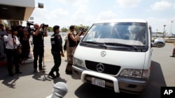 A van drives four refugees from Australia out of Phnom Penh International Airport, in Phnom Penh, Cambodia, Thursday, June 4, 2015.