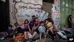 Palestinska porodica sjedi vani nakon što im je kuća pogođena u izraelskim zračnim napadima, grad Gaza, 17. maj 2021.
