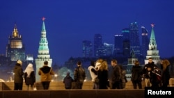 FILE - People stand on the Great Moskvoretsky Bridge, with the headquarters of Russian Foreign Ministry seen in the background, in central Moscow, Russia, March 28, 2016. 