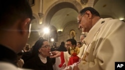 A nun takes communion from Latin Patriarch of Jerusalem Fouad Twal during Christmas midnight mass at the Church of the Nativity, traditionally believed to be the birthplace of Jesus Christ, in the West Bank town of Bethlehem early Saturday, Dec. 25, 2010.